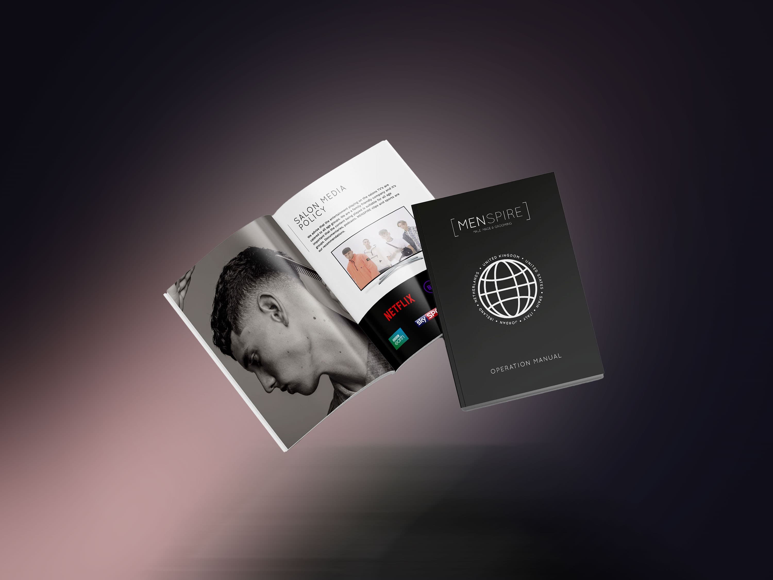 The Menspire operations manual shown as an open editorial spread and a closed volume.